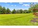 Expansive backyard featuring lush green grass, mature trees, wooden playset, and trampoline under a bright, sunny sky at 4336 Hunter Rhyne Rd # 9, Lincolnton, NC 28092