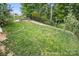 A green fenced in backyard with beautiful landscaping and trees at 4842 Durneigh Dr, Kannapolis, NC 28081