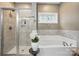 Elegant bathroom featuring a soaking tub, glass-enclosed shower, and neutral tile surround at 4842 Durneigh Dr, Kannapolis, NC 28081