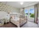 Charming bedroom with decorative wallpaper, large window, and ample natural light at 4842 Durneigh Dr, Kannapolis, NC 28081
