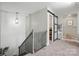 Hallway with gray wood and black metal railing and a sliding barn door across from a playroom at 4842 Durneigh Dr, Kannapolis, NC 28081
