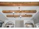 Striking ceiling with wood beams and gold chandelier above built in shelving in this neutral living area at 4842 Durneigh Dr, Kannapolis, NC 28081
