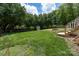 Lush backyard with mature trees, storage shed, and a trampoline at 503 New Castle Ne Ct, Concord, NC 28025