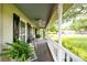 Cozy front porch with rocking chairs, ferns, ceiling fan, and classic railing perfect for relaxing outdoors at 503 New Castle Ne Ct, Concord, NC 28025