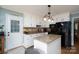 Well-lit kitchen boasts granite countertops, an island, stainless steel appliances, and classic white cabinets at 503 New Castle Ne Ct, Concord, NC 28025