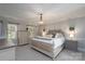 Serene main bedroom featuring a decorative chandelier, neutral tones, and ample natural light at 503 New Castle Ne Ct, Concord, NC 28025