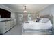 Bright main bedroom offers a decorative chandelier, ample storage with dressers, and soothing neutral colors at 503 New Castle Ne Ct, Concord, NC 28025