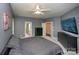 Comfortable bedroom with ceiling fan, carpet, TV, and open doors to bathroom and hallway at 6009 Swanston Dr, Charlotte, NC 28269
