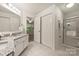 Bathroom with double closets, large vanity, and a glass-enclosed shower, with tile flooring at 6016 Gray Gate Ln # C, Charlotte, NC 28210