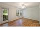 Bright bedroom featuring wood floors, a ceiling fan, and windows to the outside at 6016 Gray Gate Ln # C, Charlotte, NC 28210