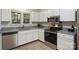 Modern kitchen with stainless steel appliances, white cabinets, granite countertops, and window views at 6016 Gray Gate Ln # C, Charlotte, NC 28210