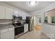 Contemporary kitchen with stainless appliances, tile floors, granite counters, and white cabinetry at 6016 Gray Gate Ln # C, Charlotte, NC 28210