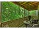 A wooden porch offers serene views of the surrounding lush greenery and comfortable outdoor seating at 6016 Gray Gate Ln # C, Charlotte, NC 28210