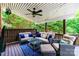 Covered deck with outdoor seating, ceiling fan, and views of the wooded surroundings at 6202 Pumpernickel Ln, Wesley Chapel, NC 28110