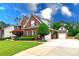 View of a two-story brick home, detached garage, and long driveway at 6202 Pumpernickel Ln, Wesley Chapel, NC 28110