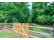 A wooden fence creates a welcoming entrance to this landscaped yard at 6202 Pumpernickel Ln, Wesley Chapel, NC 28110