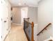 A naturally lit hallway with neutral walls and hardwood accents offers a warm welcome to your home at 6202 Pumpernickel Ln, Wesley Chapel, NC 28110