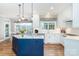 A well-lit, all-white kitchen with a blue island offers both style and functionality at 6202 Pumpernickel Ln, Wesley Chapel, NC 28110