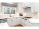 Modern kitchen featuring stainless steel appliances, white cabinets, and tiled backsplash for a pristine look at 6202 Pumpernickel Ln, Wesley Chapel, NC 28110