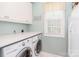 Efficient laundry room with a front-loading washer and dryer, paired with generous countertop and cabinet space at 6202 Pumpernickel Ln, Wesley Chapel, NC 28110
