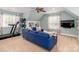 Spacious living area with a blue couch, workout machine, and mounted television at 6202 Pumpernickel Ln, Wesley Chapel, NC 28110