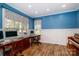 Office with hardwood floors, white trim, piano, and blue walls at 6202 Pumpernickel Ln, Wesley Chapel, NC 28110