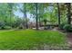Spacious backyard with manicured lawn and wooded area, perfect for outdoor activities at 6208 Rocky Falls Rd, Charlotte, NC 28211