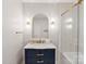 This bathroom features gold hardware, marble countertop, navy vanity, and a glass door to the tub at 6208 Rocky Falls Rd, Charlotte, NC 28211
