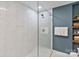 This bathroom features a glass shower with white marble tile, and a blue accent wall with wood shelving at 6208 Rocky Falls Rd, Charlotte, NC 28211
