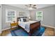 This bedroom features a ceiling fan, wood floors, area rug, and two large windows at 6208 Rocky Falls Rd, Charlotte, NC 28211