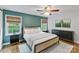 Relaxing bedroom with natural light, stylish decor, a ceiling fan, and dark wood accents at 6208 Rocky Falls Rd, Charlotte, NC 28211