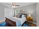 This bedroom features a ceiling fan, wood floors, area rug, and a large bed at 6208 Rocky Falls Rd, Charlotte, NC 28211