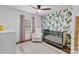 This Bedroom features a crib, rocker, patterned accent wall, and pink curtains and is perfect for a baby at 6208 Rocky Falls Rd, Charlotte, NC 28211