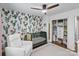 This Bedroom features a crib, rocker, patterned accent wall, closet, and plenty of storage space at 6208 Rocky Falls Rd, Charlotte, NC 28211