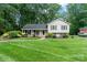 Charming home with a manicured lawn, mature trees, and a welcoming front entrance at 6208 Rocky Falls Rd, Charlotte, NC 28211