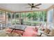 Relaxing sun room featuring lots of natural light, ceiling fan, and view of the landscaped yard at 6208 Rocky Falls Rd, Charlotte, NC 28211