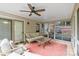 This sunroom features tile floors, ceiling fan, brick accent wall, and plenty of windows to let light in at 6208 Rocky Falls Rd, Charlotte, NC 28211