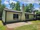 Back of home showing yard, chimney, sliding glass doors and green lawn surrounded by trees at 7228 Rollingridge Dr, Charlotte, NC 28211