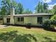 Home backyard featuring a white painted chimney with grass lawn surrounded by trees at 7228 Rollingridge Dr, Charlotte, NC 28211