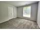 Bedroom with neutral carpet, light walls, closet, and a window with natural light at 7228 Rollingridge Dr, Charlotte, NC 28211