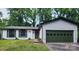 A charming single-story home with green door and garage, nestled among tall trees at 7228 Rollingridge Dr, Charlotte, NC 28211