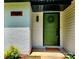 Close-up of a vibrant green front door with brick and siding at 7228 Rollingridge Dr, Charlotte, NC 28211