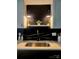 Modern kitchen featuring white countertop, sink, and black marble backsplash with soft modern lighting at 7228 Rollingridge Dr, Charlotte, NC 28211