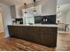 Contemporary kitchen featuring black cabinets, countertop, and modern appliances, next to dining room at 7228 Rollingridge Dr, Charlotte, NC 28211