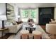 Bright living room with large windows, a dark fireplace, and neutral decor at 7228 Rollingridge Dr, Charlotte, NC 28211