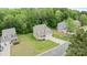 Aerial view of a home with well manicured lawn, a driveway, and surrounded by mature trees at 7308 Rothmore St, Charlotte, NC 28215