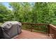 Spacious wooden deck overlooking lush greenery and includes a covered grill at 7308 Rothmore St, Charlotte, NC 28215