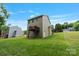 Exterior view showcasing a spacious backyard with green grass and the rear of the house, including a deck at 7308 Rothmore St, Charlotte, NC 28215