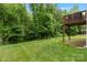 A lush green backyard with a well-maintained lawn and a partial view of a wooden deck at 7308 Rothmore St, Charlotte, NC 28215