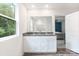 Bright bathroom featuring a double vanity with granite countertop and modern white cabinetry and a view into an adjacent bedroom at 7308 Rothmore St, Charlotte, NC 28215